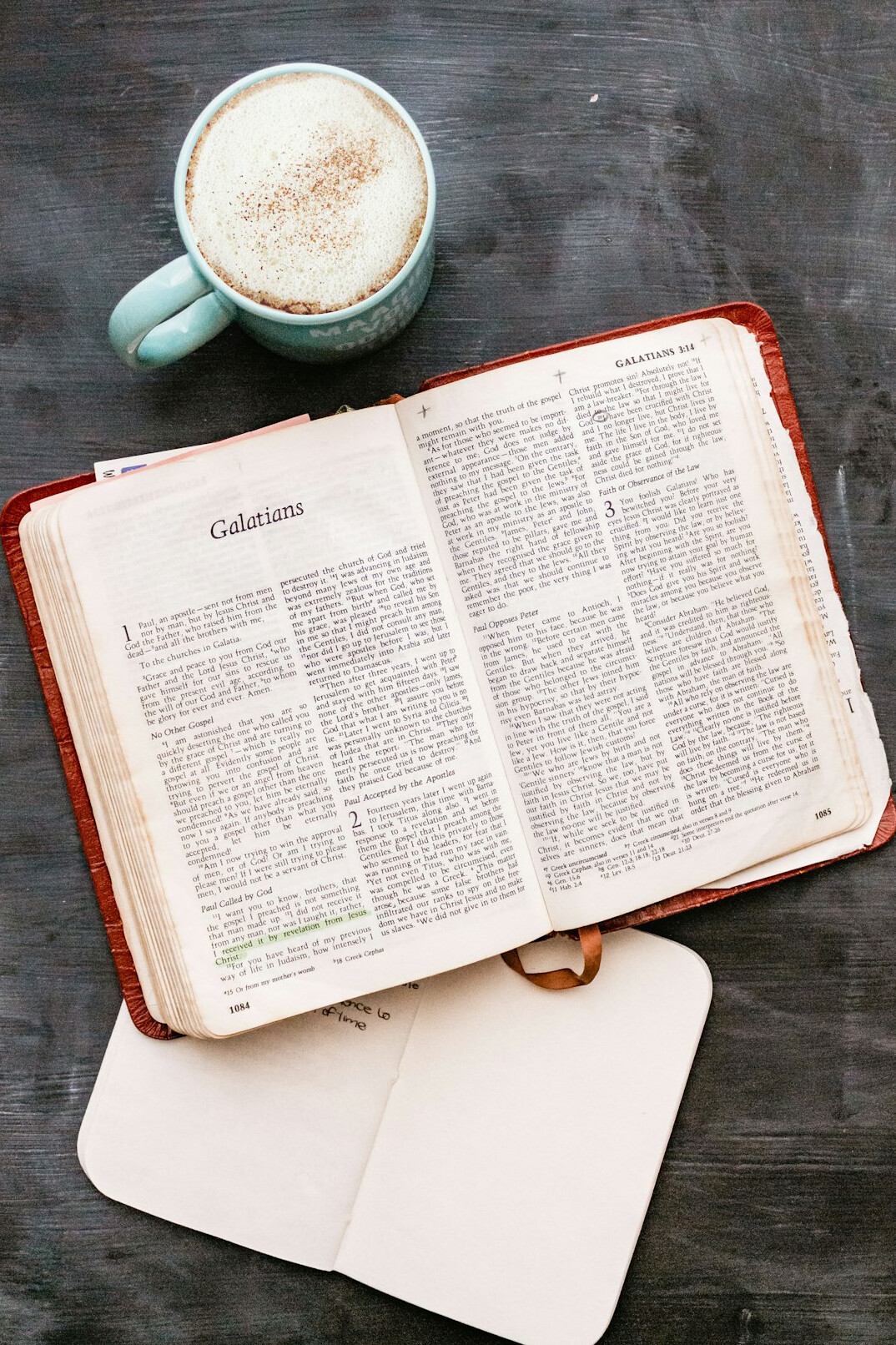 Open notebook with handwritten notes beside a cup of coffee