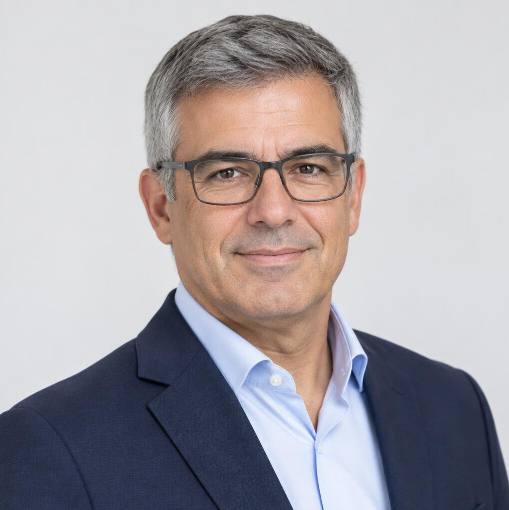 Studio portrait of a middle-aged Portuguese man with short grey hair and glasses